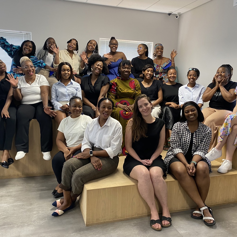 A group of women smiling and cheering towards the camera for a posed group photo