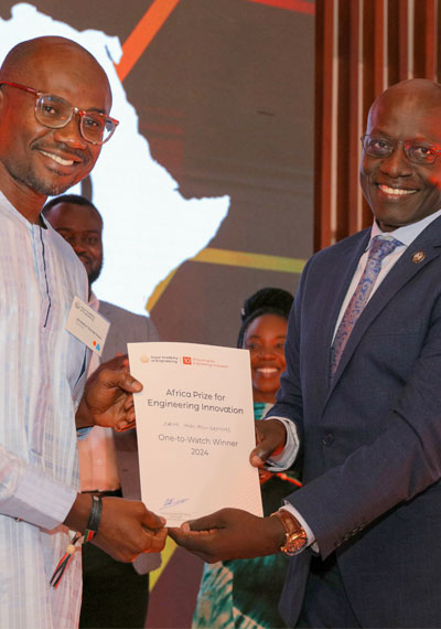 Ghanaian man receiving an award from a judge at the Africa Prize final